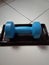 A cute medium blue dumbbell on a brown plastic box