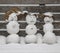Cute mini snowmen on snowy winter day