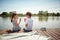 Cute minor couple sitting by the river eating watermelon