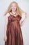 Cute mix raced plus size woman in long formal dress on white studio background standing alone
