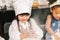 Cute mixed race and African American kid girls baking or cooking together in home kitchen