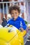 Cute mixed race little boy enjoying a ride on a fun carnival carousel ride. A happy boy Smiling and having fun riding a amusement