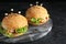Cute monster burgers served on black table. Halloween party food