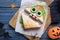 Cute monster sandwich served on wooden table, flat lay. Halloween party food