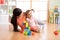 Cute mother and child girl play with cubes together