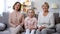 Cute mother daughter and grandma sitting on sofa and smiling, social insurance