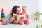 Cute mother and daughter playing together, reading first book