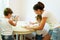 A cute mother and her children sculpt dough in the kitchen