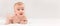 Cute naked 3-4 months baby lying on stomak, smiling. Pretty blonde caucasian girl with adorable smile, healthy skin