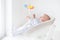 Cute newborn baby boy watching colorful mobile toy