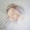 Cute newborn baby girl with crown jewelry sleeping ona grey blanket