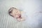 Cute newborn baby girl with crown jewelry sleeping ona grey blanket