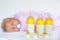 Cute newborn baby girl with nursing bottles and pacifier