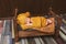 Cute newborn baby in hat on a brown bed and yellow pillow . Sleeping baby on a dark background. Closeup portrait of newborn baby.