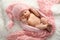 Cute newborn baby in hat lying on fuzzy blanket, top view