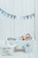 cute newborn baby in hat sleeping in wooden baby cot with star pillow