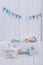 cute newborn baby in hat sleeping in wooden baby cot with star pillow