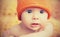 Cute newborn baby in knitted orange hat cap