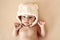 Cute newborn baby in winter warm hat with bear ears funny lying