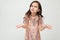 Cute offended teenager girl shiny dress indignant on a white studio background