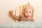 cute one-and-a-half-year-old girl with a ponytail on top of her holding a pancake sitting at table