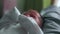 A cute one month old newborn baby is laying on his back and crying
