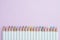 Cute pastel color pencils on pink paper background with copy spa