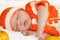 Cute peaceful sleeping newborn baby dressed in a knitted orange