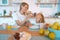 Cute photo of mom and daughter having breakfast with donuts and tea. cuddling and looking at the camera