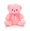 Cute pink bear doll with bow on white background with shadow reflection. Playful bright pink bear.