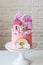 Cute pink birthday cake for a little girl with fondant unicorn, gingerbread princess castle, rainbow and meringue