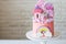 Cute pink birthday cake for a little girl with fondant unicorn, gingerbread princess castle, rainbow and meringue