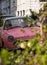 Cute pink Nissan Figaro retro style car, parked in a mews street in Queen`s Gate, Kensington, London UK.