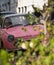 Cute pink Nissan Figaro retro style car, parked in a mews street in Queen`s Gate, Kensington, London UK.