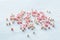 Cute pink and white beads are scattered on a white background, a festive pattern for a close-up wedding design. Hobby, craft and