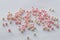 Cute pink and white beads are scattered on a white background, a festive pattern for a close-up wedding design. Hobby, craft and