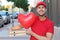 Cute pizza delivery guy holding pizzas and heart shaped balloon