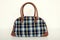 Cute plaid bag. Green with brown tartan bag on white.