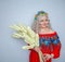 Cute plump girl from the village in a red summer sundress with a sheaf of wheat in her hands on white studio solid background