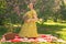 Cute plus size caucasian girl wearing a cute vintage yellow dress and enjoying a vacation in the summer Park on the green grass. c