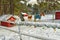 Cute ponies and horses behind a simple fence in the snow decorated with Christmas New Year decorations and a snowy forest.