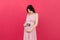 Cute Pregnant Lady Posing With Baby Sonography Photo Near Colored background. Concept of pregnancy, gynecology, medical