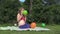 Cute pregnant woman girl inflate colorful balloon in garden