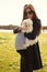 Cute pregnant woman with sun glasses holding little siamese dog