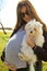 Cute pregnant woman with sun glasses holding little siamese dog closeup