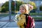 Cute preschool child, waiting on a red light to cross the street, caring bouquets of flowers for teachers, going to preschool