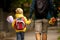 Cute preschool child, waiting on a red light to cross the street, caring bouquets of flowers for teachers, going to preschool