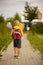 Cute preschool child, waiting on a red light to cross the street, caring bouquets of flowers for teachers, going to preschool