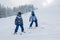 Cute preschool children, skiing in Austrian winter resort on a c
