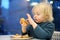 Cute preschooler boy eating large hamburger at fast food restaurant. Unhealthy meal for kids. Junk food. Overweight problem child